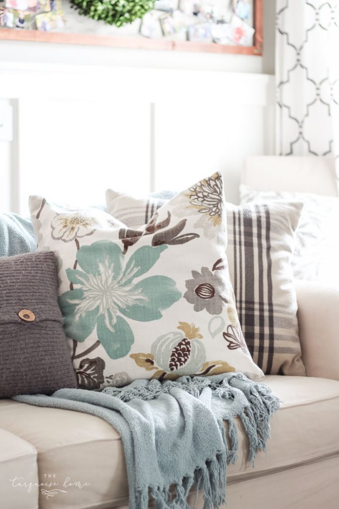 turquoise and gray floral pillow on sofa