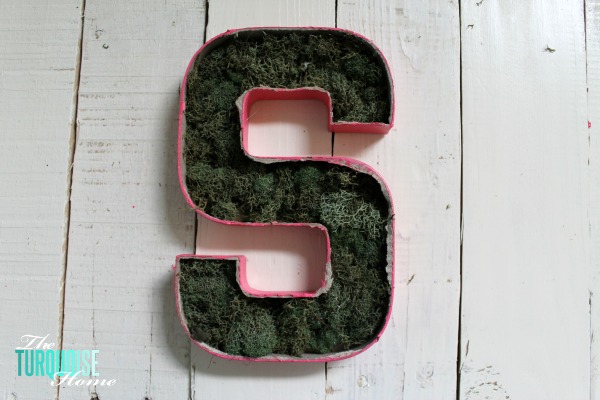 Cut the top off of a simple paper mache initial from Hobby Lobby and fill it with moss and flowers for a sweet addition to a baby girl's nursery. | DIY Flower and Moss Initial Art via TheTurquoiseHome.com