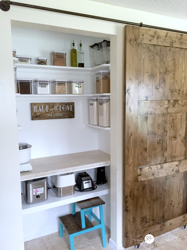 A sliding barn door that reveals baking goods on shelves.