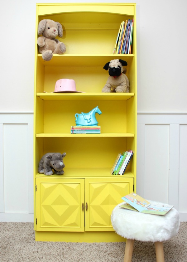 Bright yellow bookshelf with childrens animals on it.