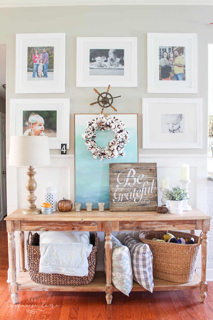 A cozy console table and gallery wall decked out for fall in simple, turquoise and wood toned elements