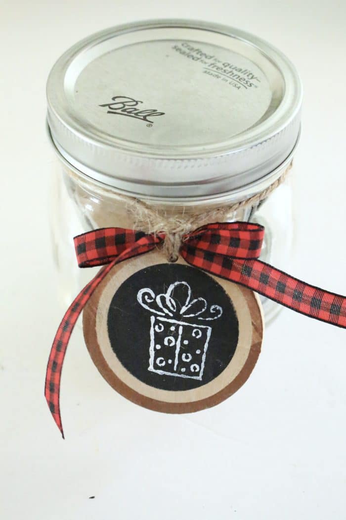 A wood slice ornament tag on a mason jar.