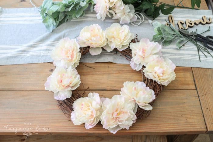 Add the peonies first to the lamb's ear wreath.