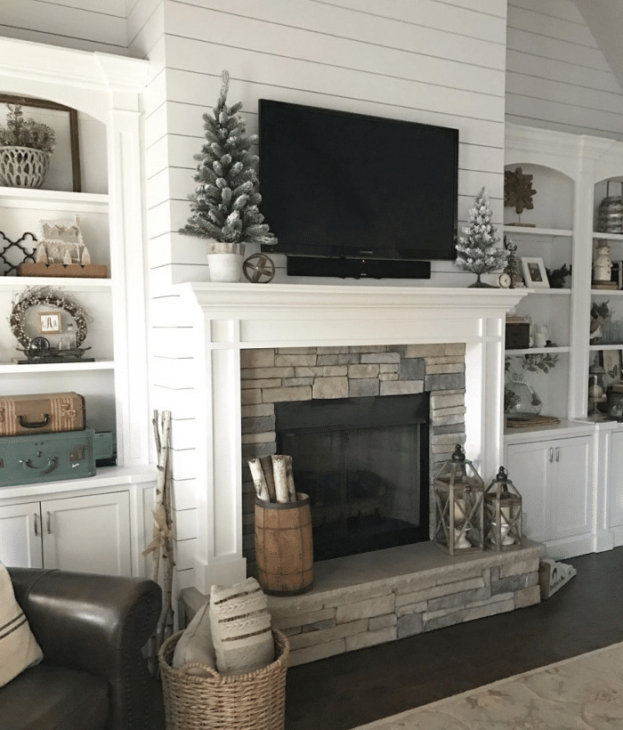 Winter decorated mantel with TV above it