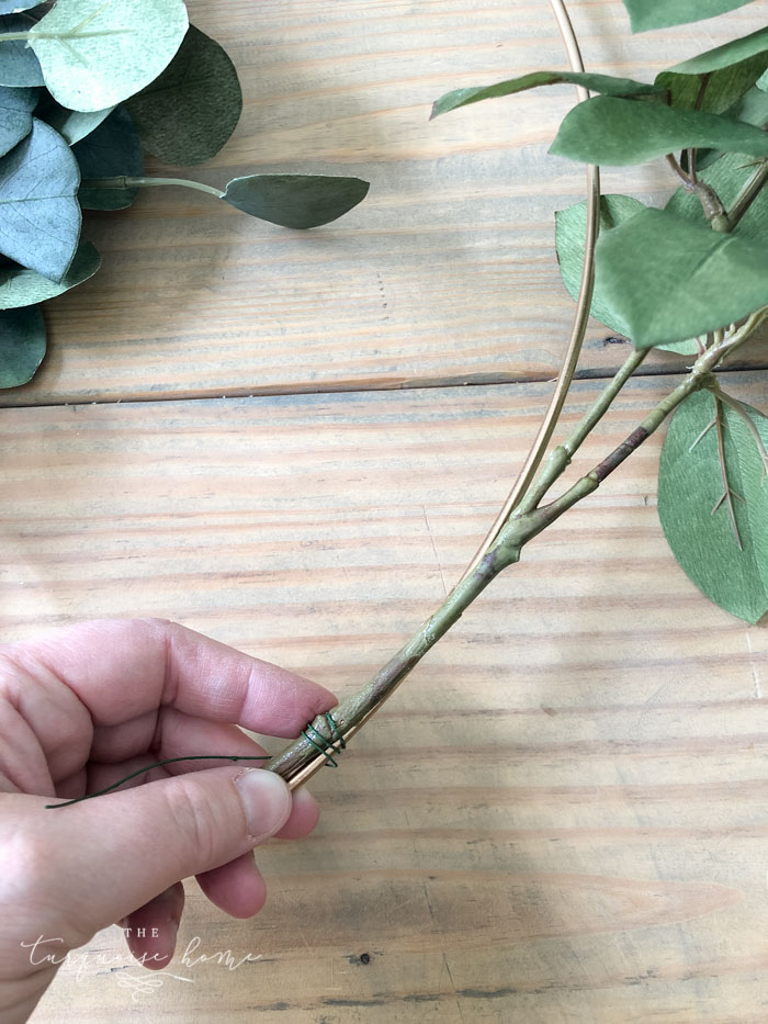 Attach the floral and fruit stems to the wreath hoop.