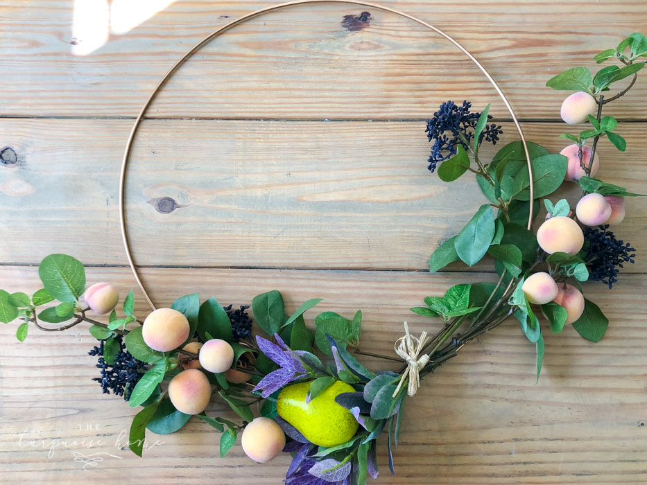 Attach the floral and fruit stems to the wreath hoop.