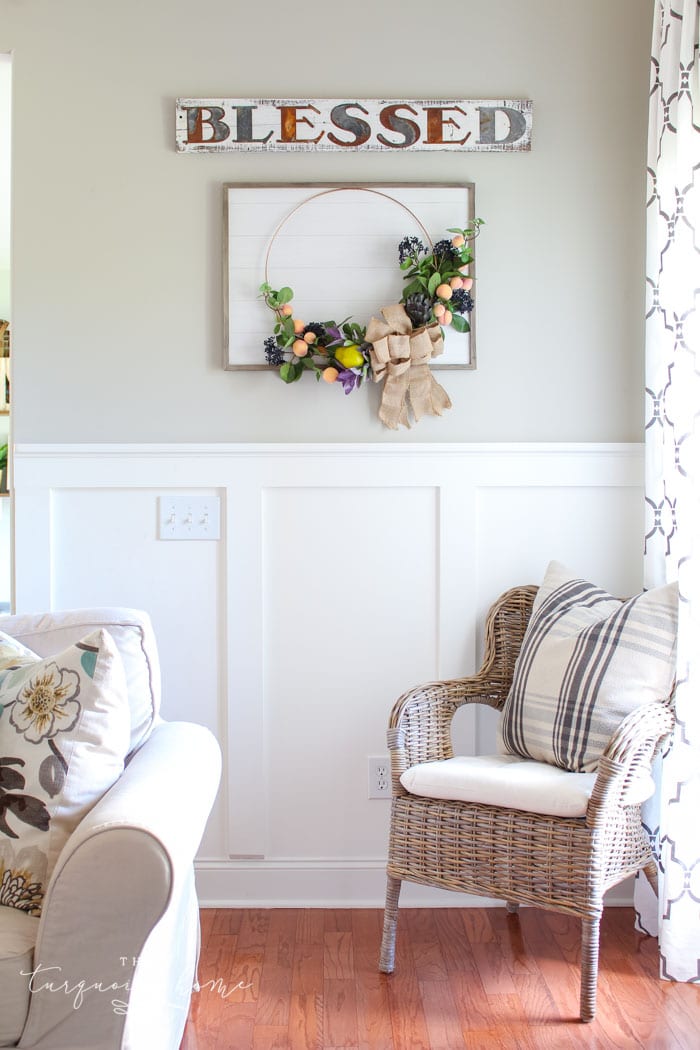 Gorgeous fall wreath with fruit on a "shiplap" framed backdrop.