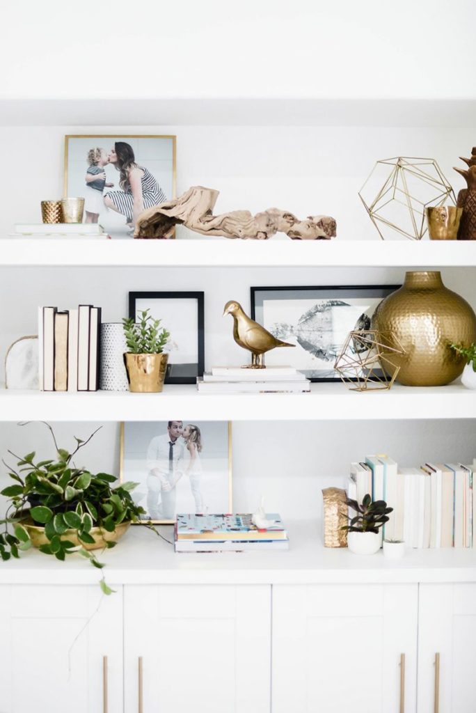 How to Style a Bookshelf -->> White shelving styled with gold sculpture and books