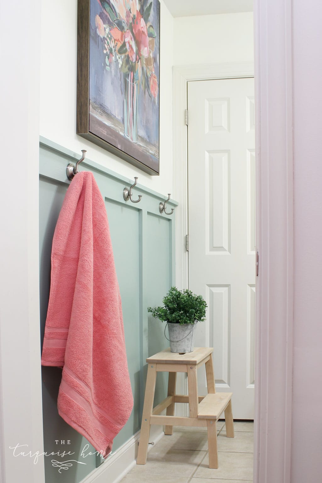 Beautiful board and batten in a bathroom with hooks for hanging towels - in a fun color called Wythe Blue.