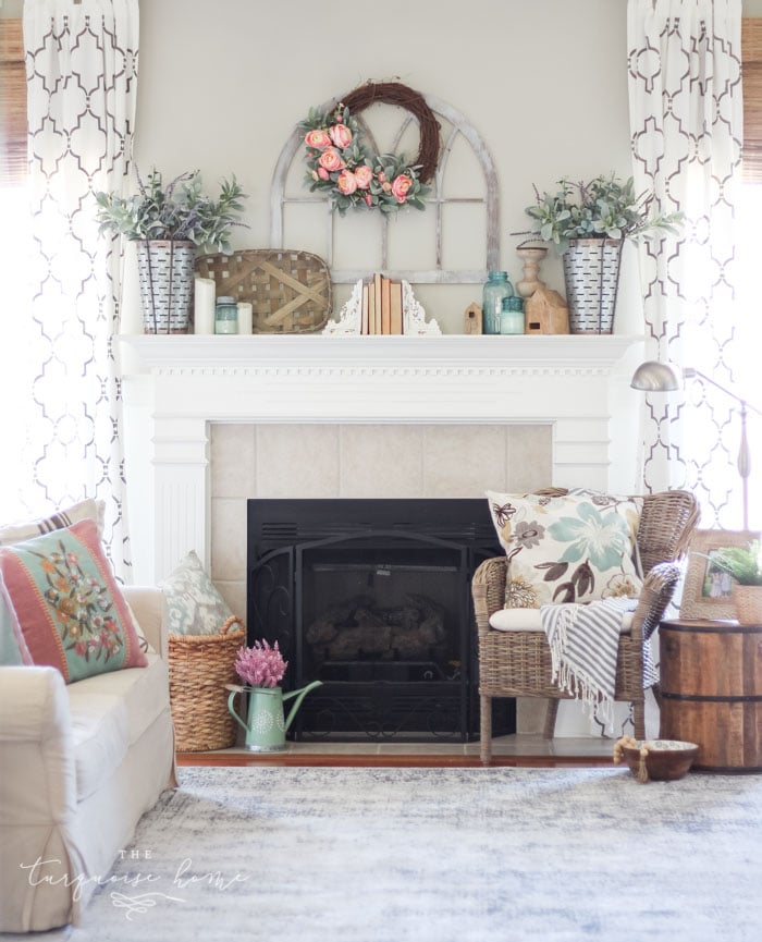 white wood mantel with farmhouse decor in a living room with sitting chair and sofa.