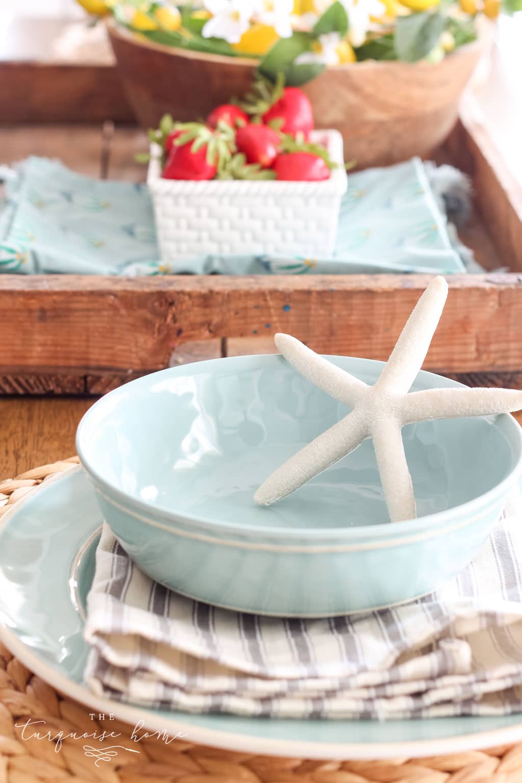 Simple summer place setting with blue bowls and white starfish decor.