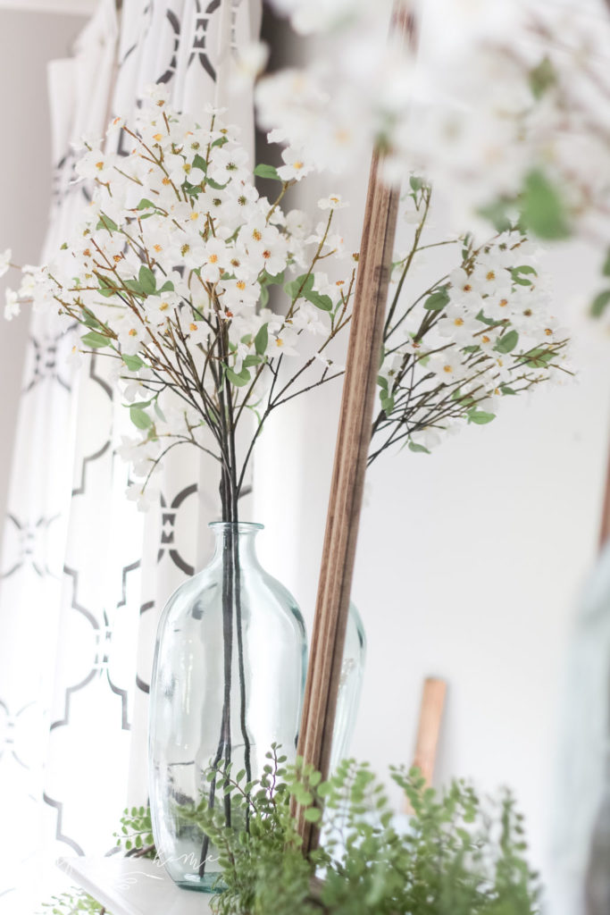 A Simple Summer Mantel -->> wood mirror, glass vase, dogwood stems and locust garland