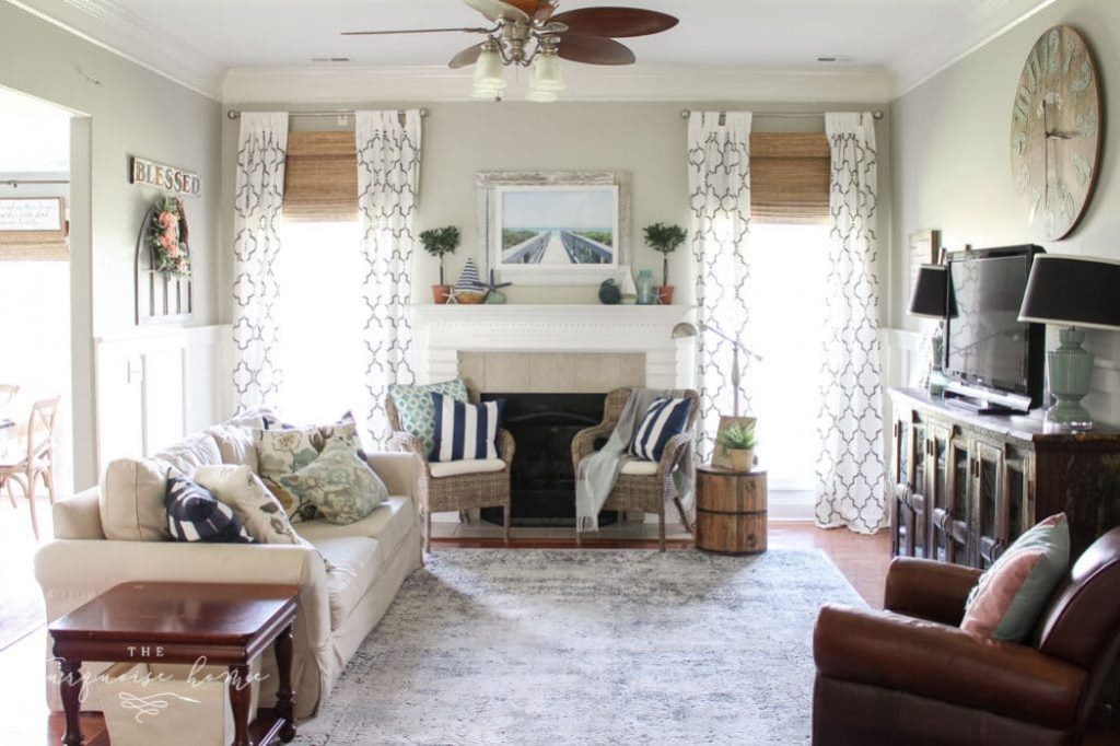 living room that uses home and decor to create a comfortable space with a sofa and two chairs in front of a fireplace.