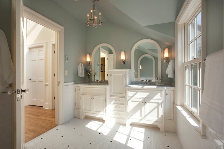 Wythe Blue bathroom with white custom cabinets and arched mirrors.