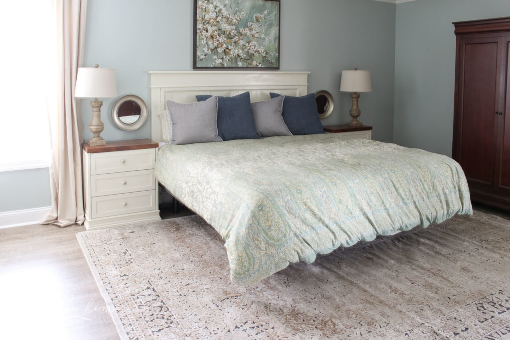 Gorgeous Ivory and Beige Antique-style Rug in a Farmhouse Master Bedroom. What size rug to buy for a king bed?