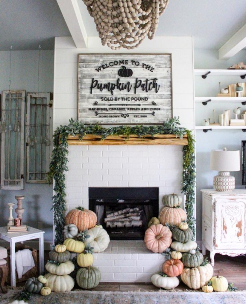 Gorgeous fall decor that can transition into Halloween with stacks of pumpkins all over the fireplace hearth!