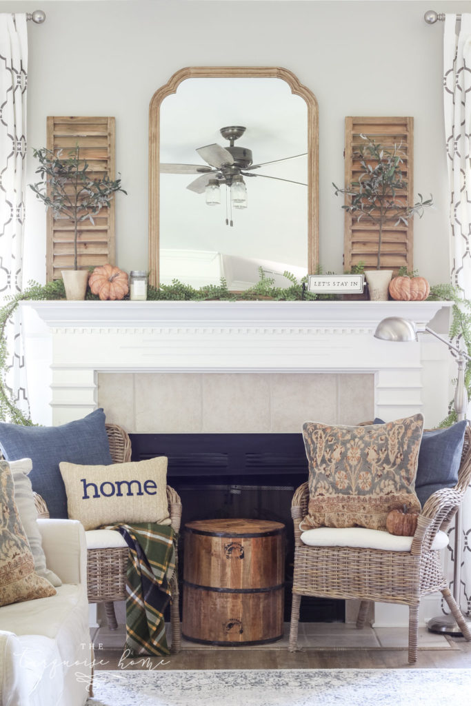 Beautiful neutral fall mantel with blues and browns and beautiful fall greenery.