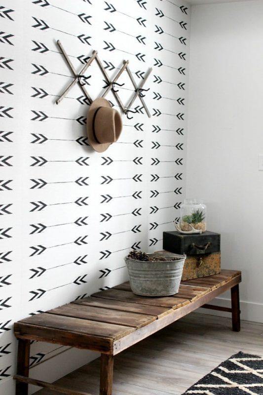 hallway with wooden bench and white wallpaper with black arrows