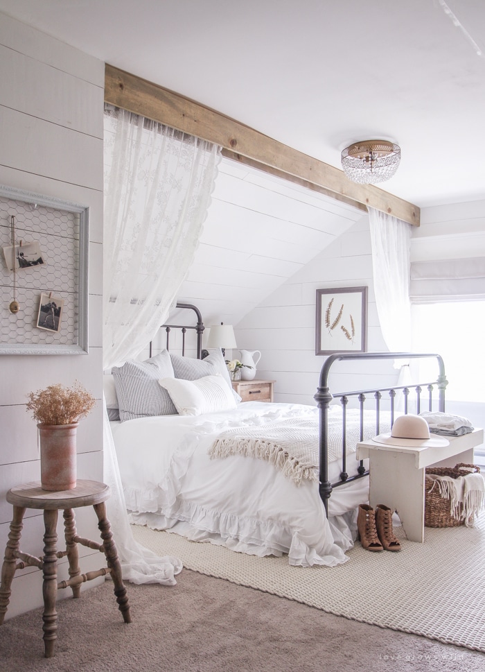 modern farmhouse bedroom with a bed, shiplap walls, and an area rug on the floor