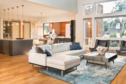 open concept living room space with a sectional couch, coffee table and area rug