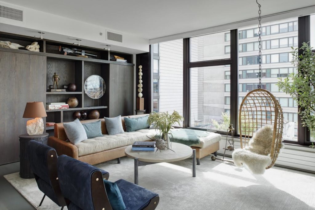 living room with a wall of bookshelves, a sectional couch, chairs, and a coffee table