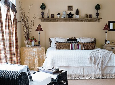 a shelf hangs above a bed with trinkets and objects on top