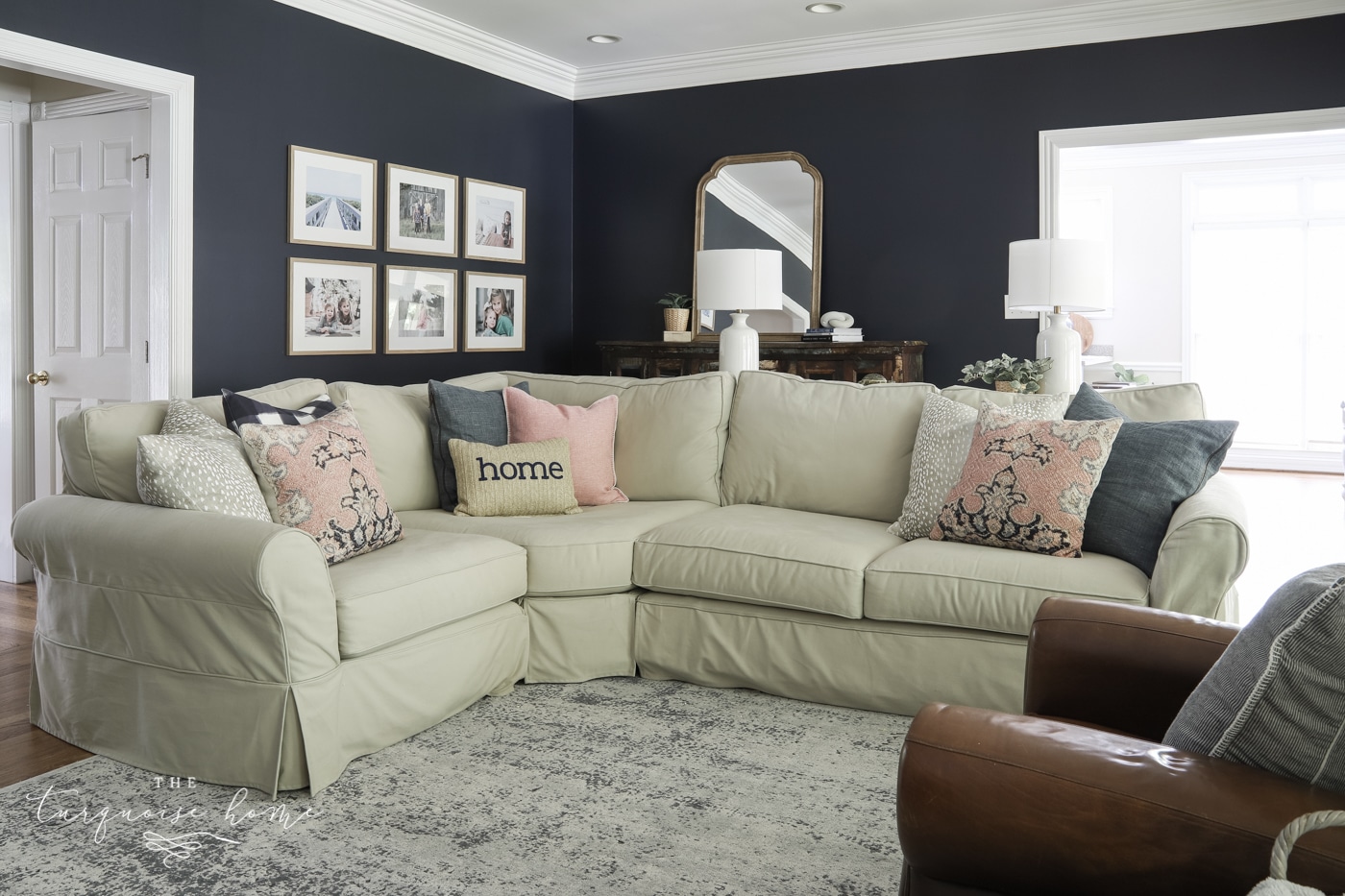 living room with a sectional couch with throw pillows in the corner