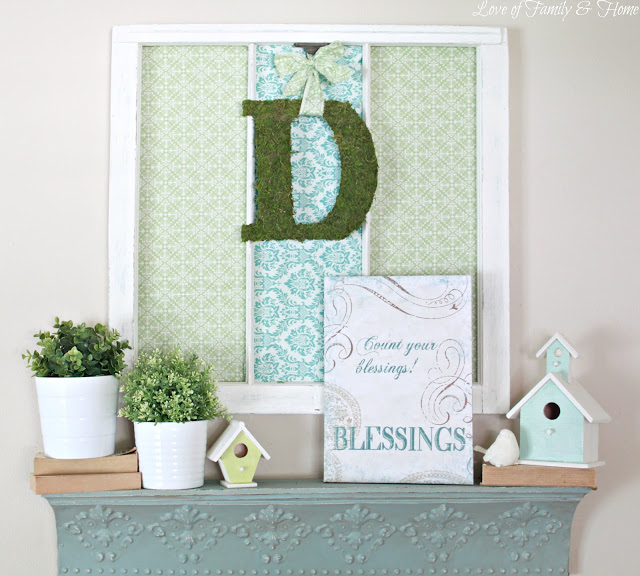blue and green mantel decor with greenery and birdhouses