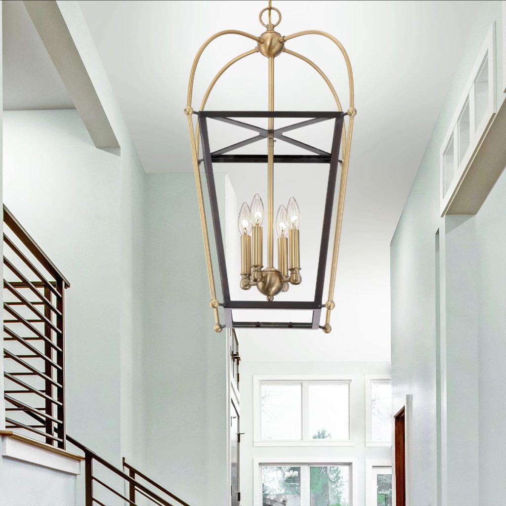 Two-toned entryway light hanging in a tall foyer