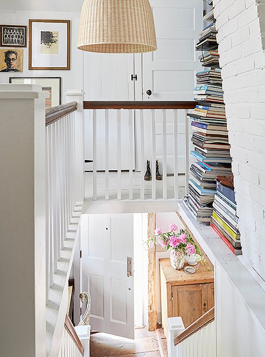 Books stacked in an open space at the top of the stairway