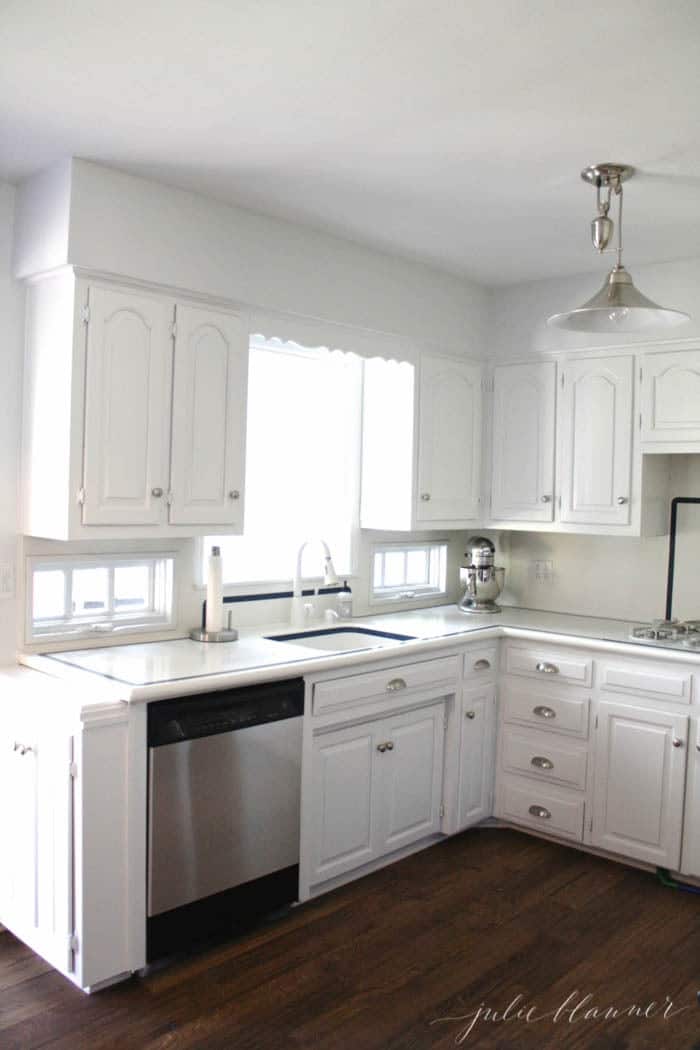 white kitchen with black and stainless steel dishwasher