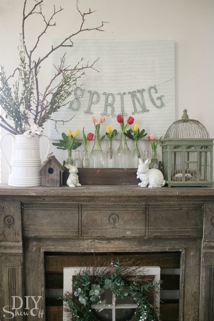 spring decor mantel with bunnies, bird cage, tulips and a spring sign