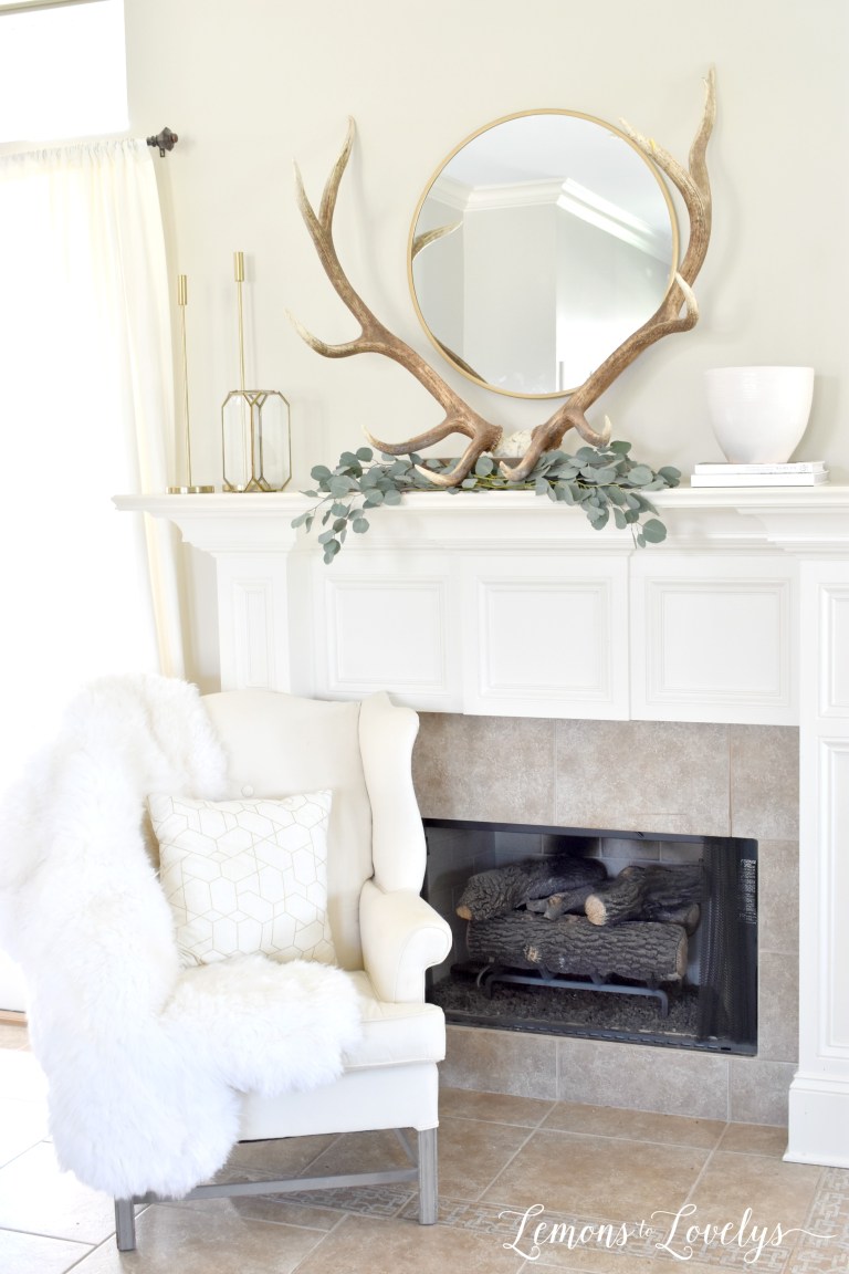 spring mantel decor with antlers, eucalyptus leaves, and a circle mirror
