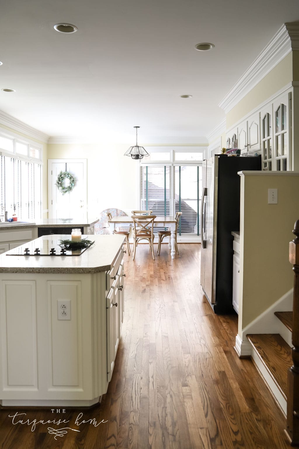 basic 90's kitchen with old light, wood floors and yellow walls.