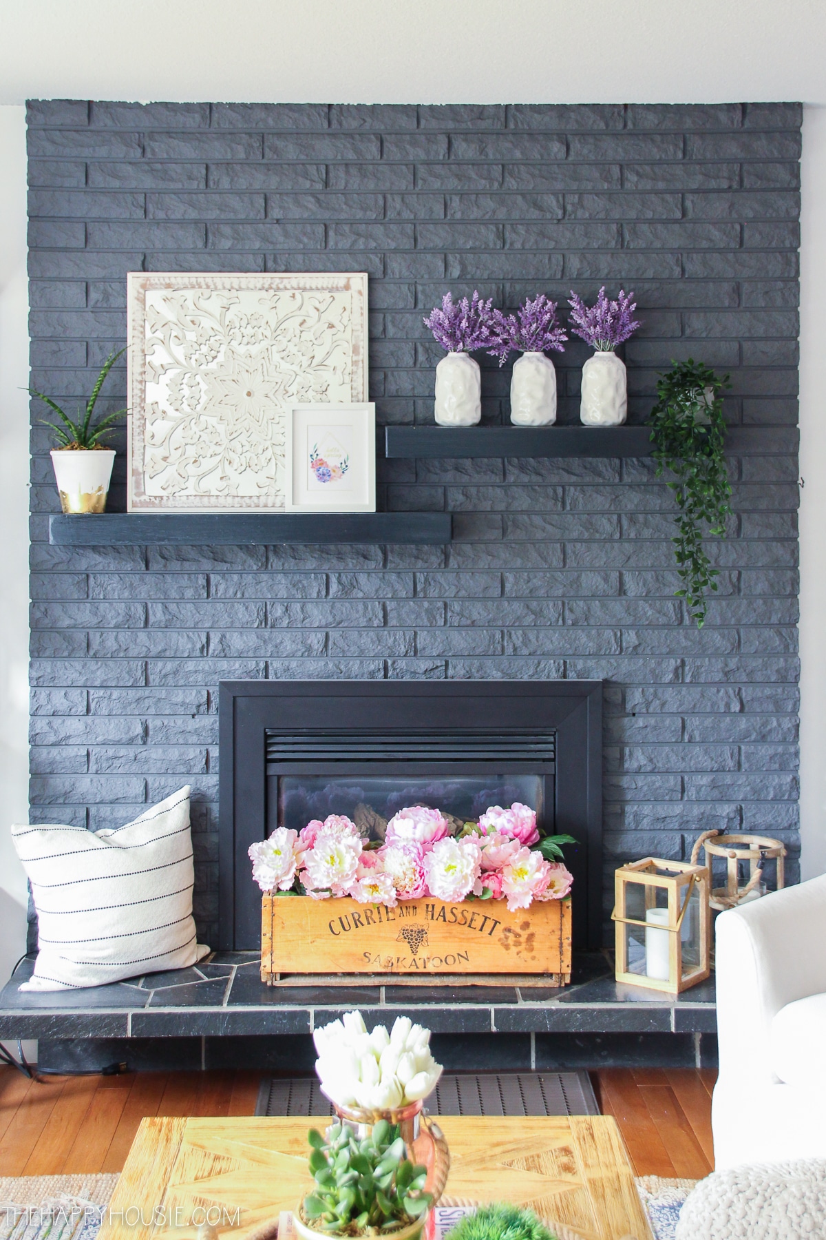 dark gray brick fireplace with spring flower blooms on mantel