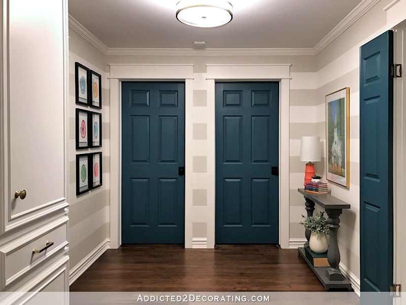 foyer with neutral decor and deep blue painted interior doors