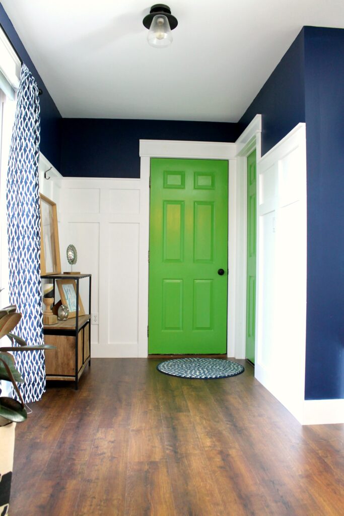 mud room with navy walls, white trim, and bright green interior doors