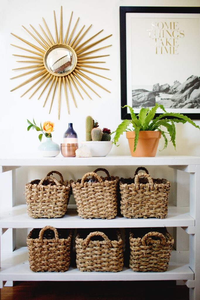 Styled entryway with shelving unit, baskets and plants.