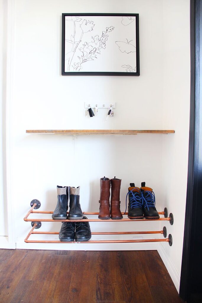 Small entryway shoe storage ideas: DIY wall-mounted copper pipe rack for shoes, a shelf and hooks for keys.