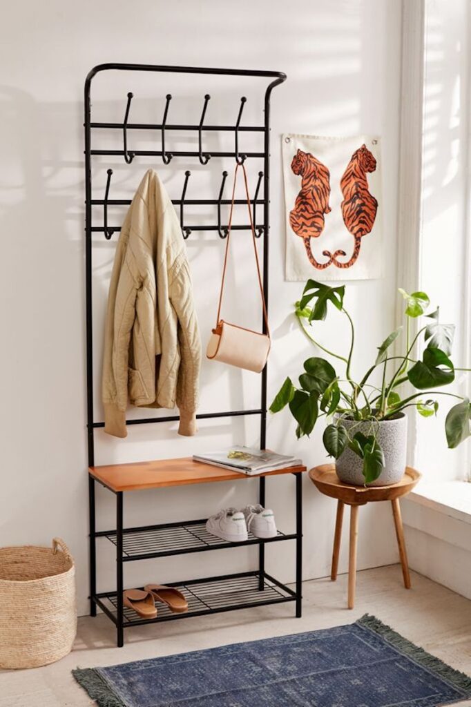 All-in-one entryway storage rack, styled with a plant and tiger art piece.