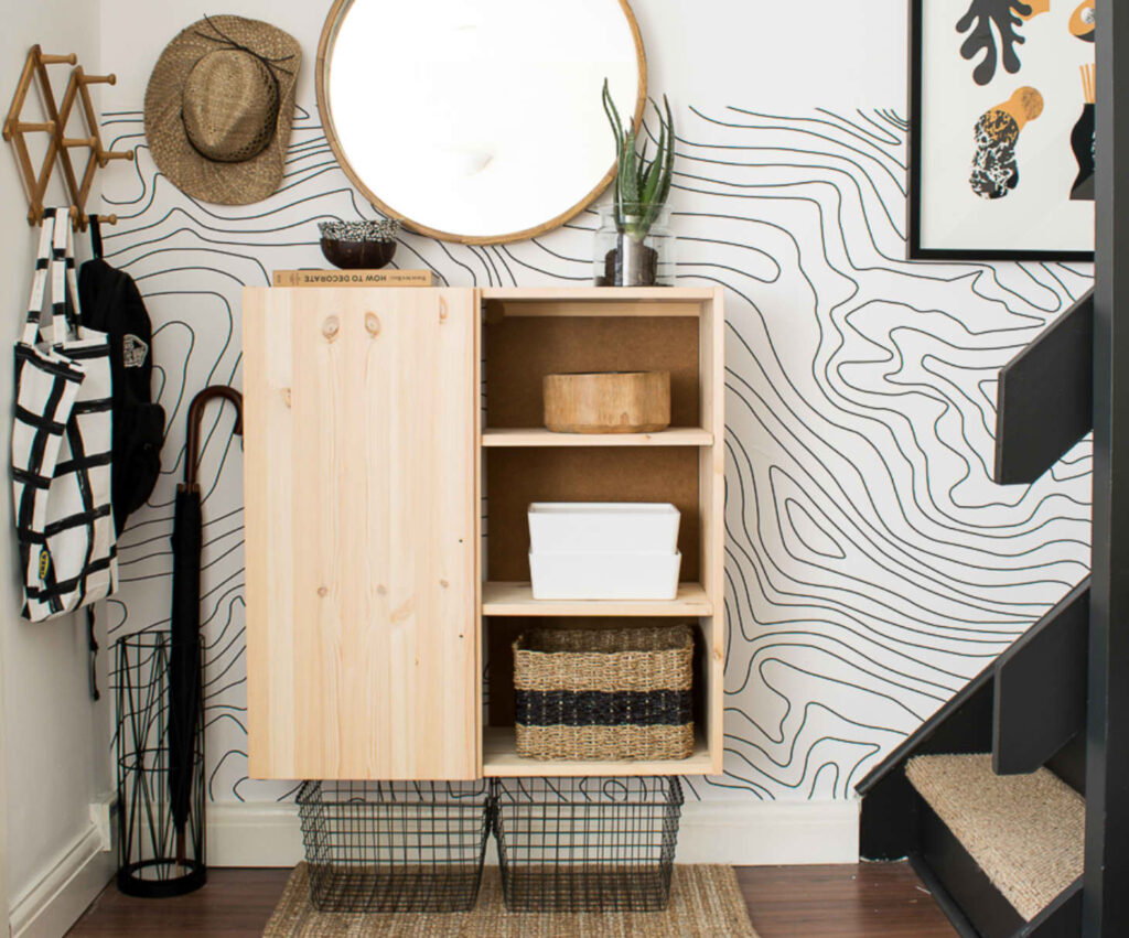 Wall-mounted IKEA cabinet, accordion wall hooks, baskets and umbrella holder keeps all belongings corralled in a small space.