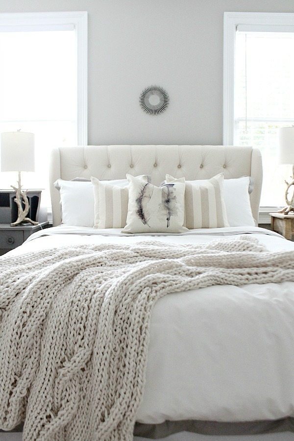 Peaceful bedroom with an off-white decor palette and Sherwin Williams Mindful Gray wall color.