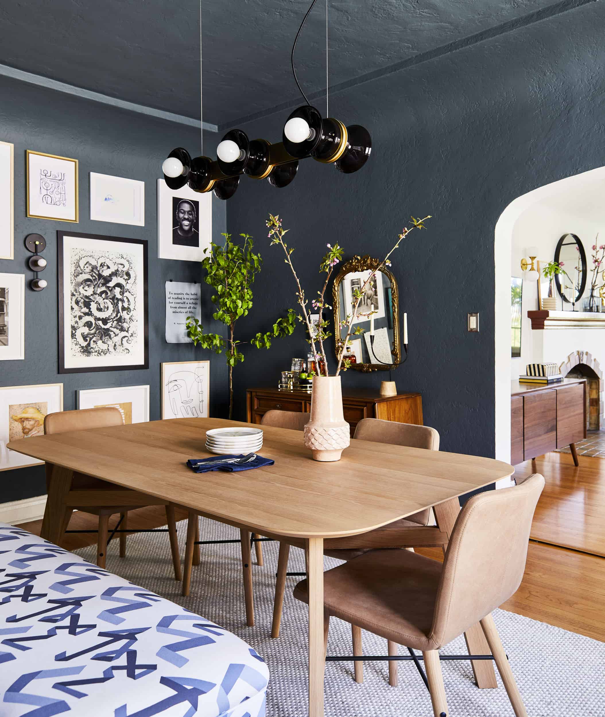 Best dark blue green paint colors: Inchyra Blue by Farrow & Ball in a dining room with curved walls and gallery wall.
