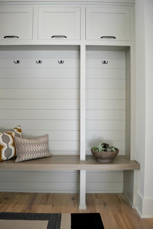 Mindful Gray built-in bench and cabinets in a minimally decorated mudroom.