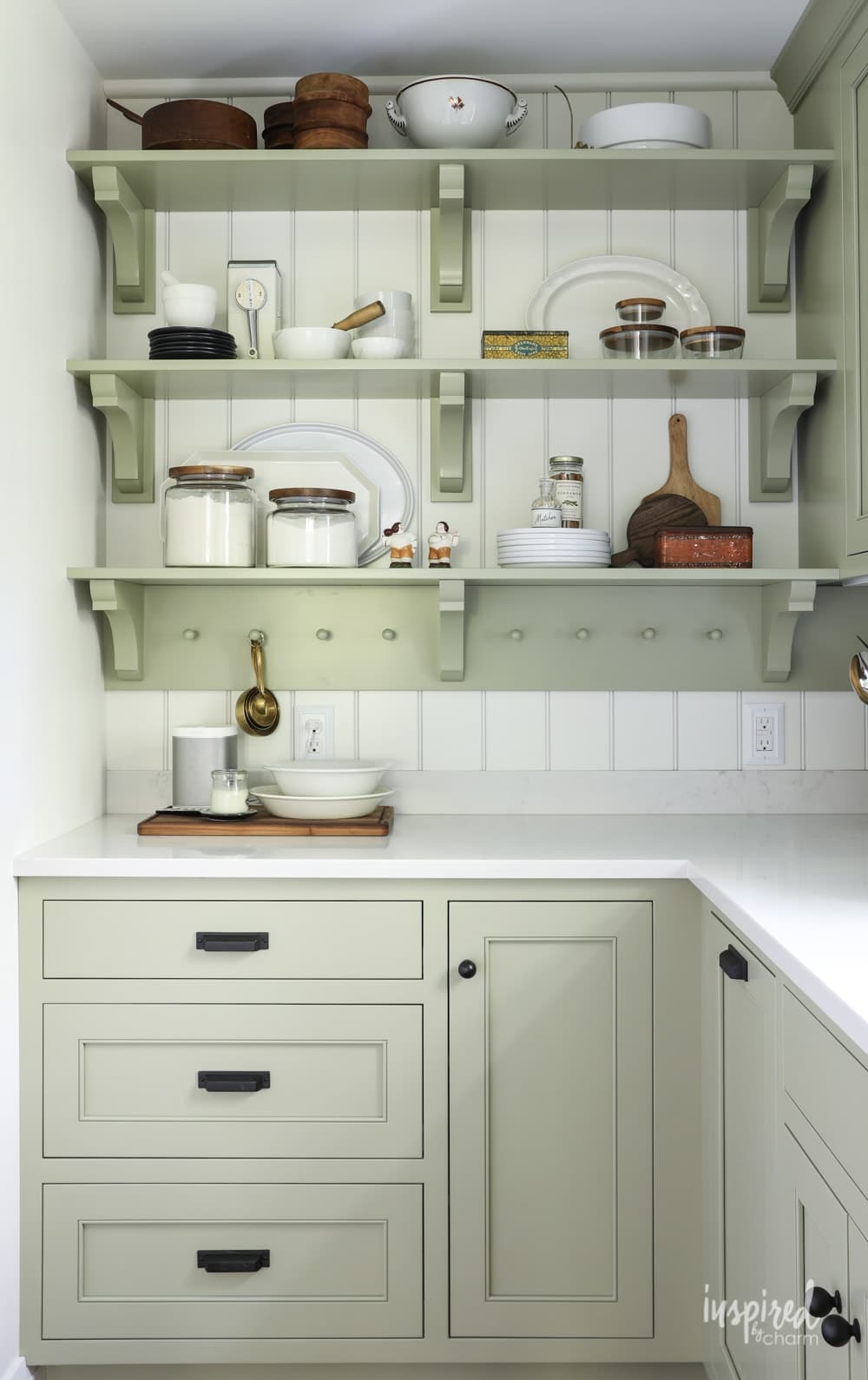 Kitchen cabinets and open shelving in Sage by Sherwin Williams.