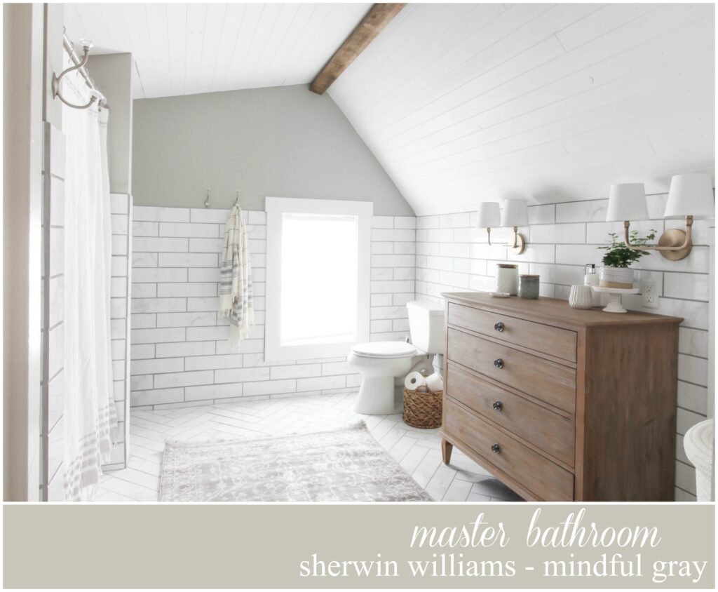 relaxing gray and white bathroom with subway tile, wood dresser and vintage-style rug.