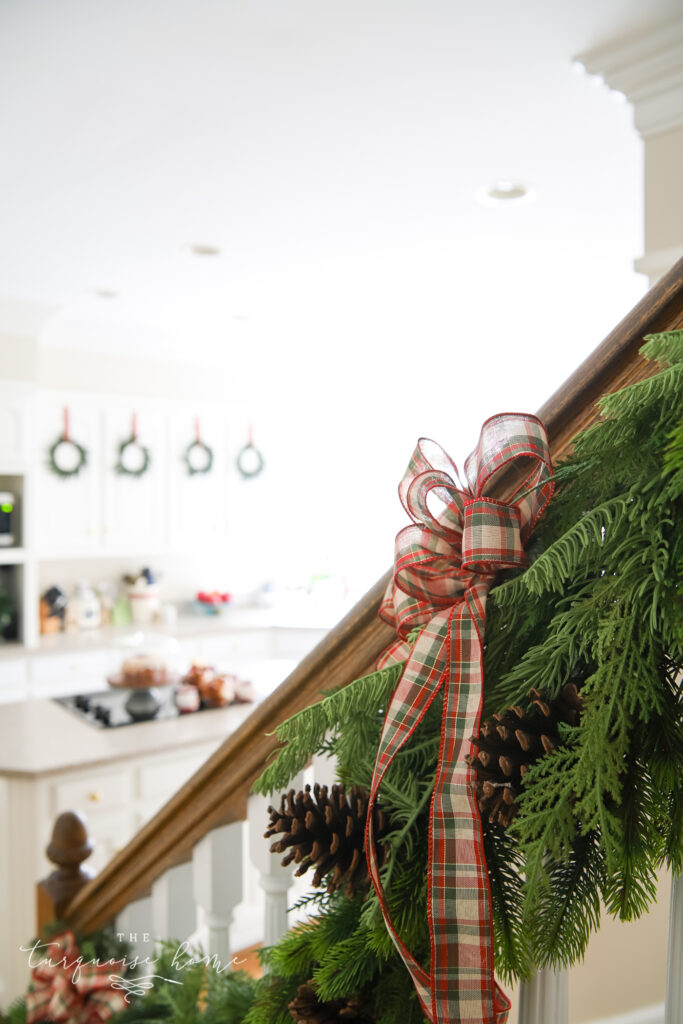 Red Plaid Bow on the Greenery on the Stair Banister