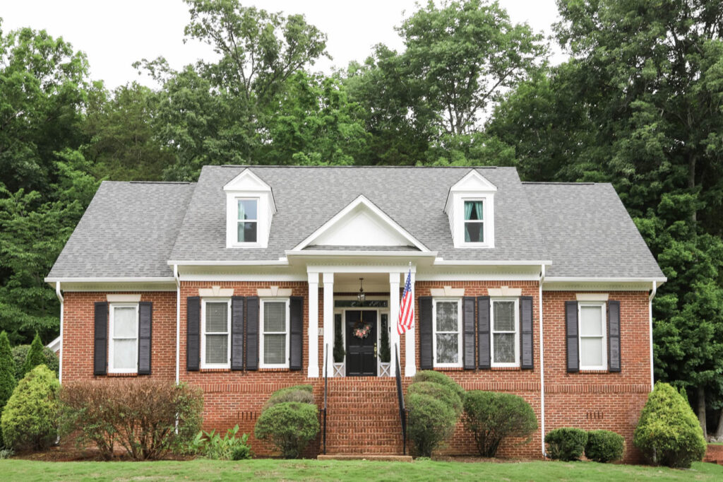 Red Brick House with White Trim and Black Shutters