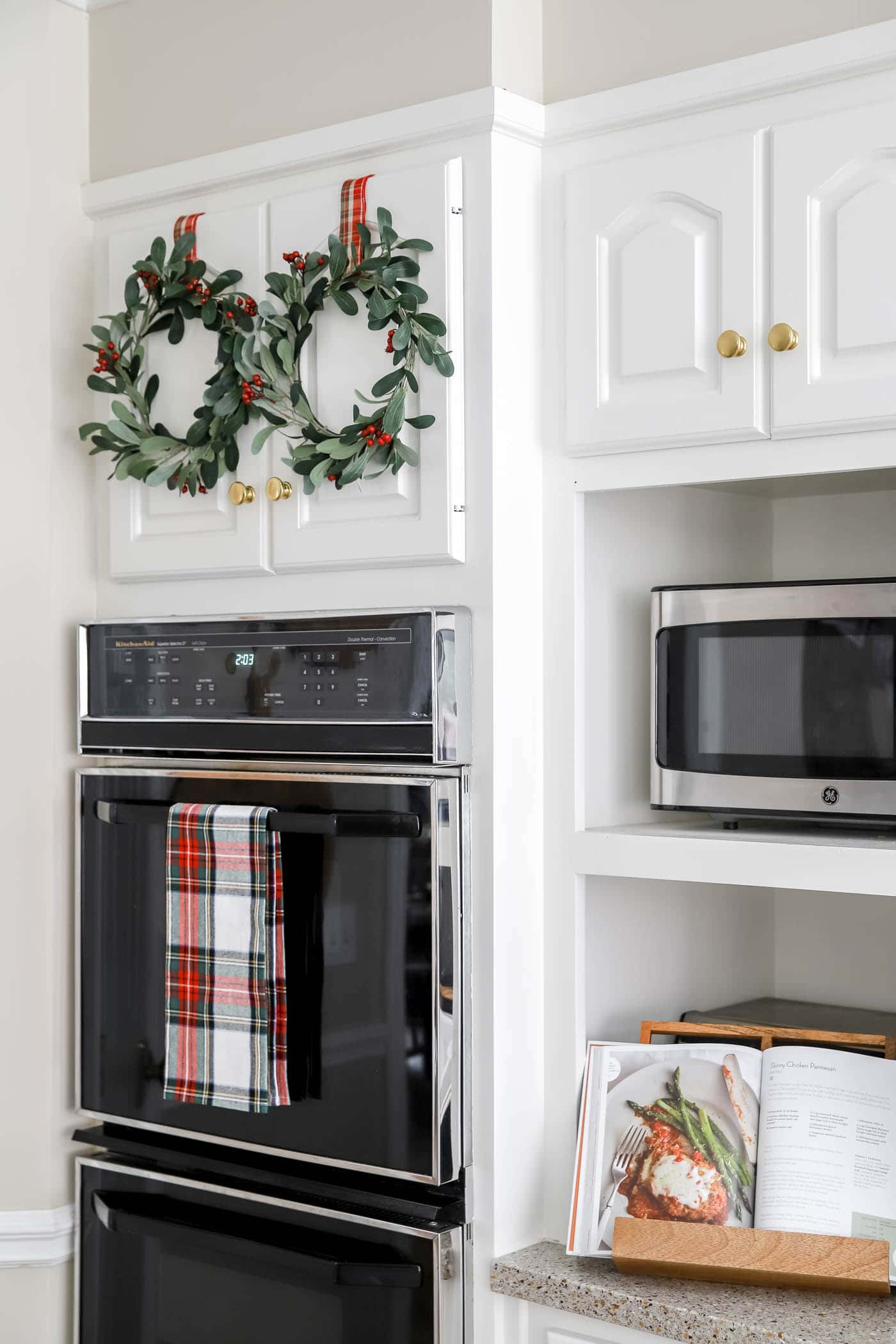 Christmas kitchen with mini wreaths on cabinets