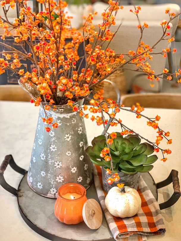 Fall flower arrangement with bittersweet branches, succulent, pumpkin, candle